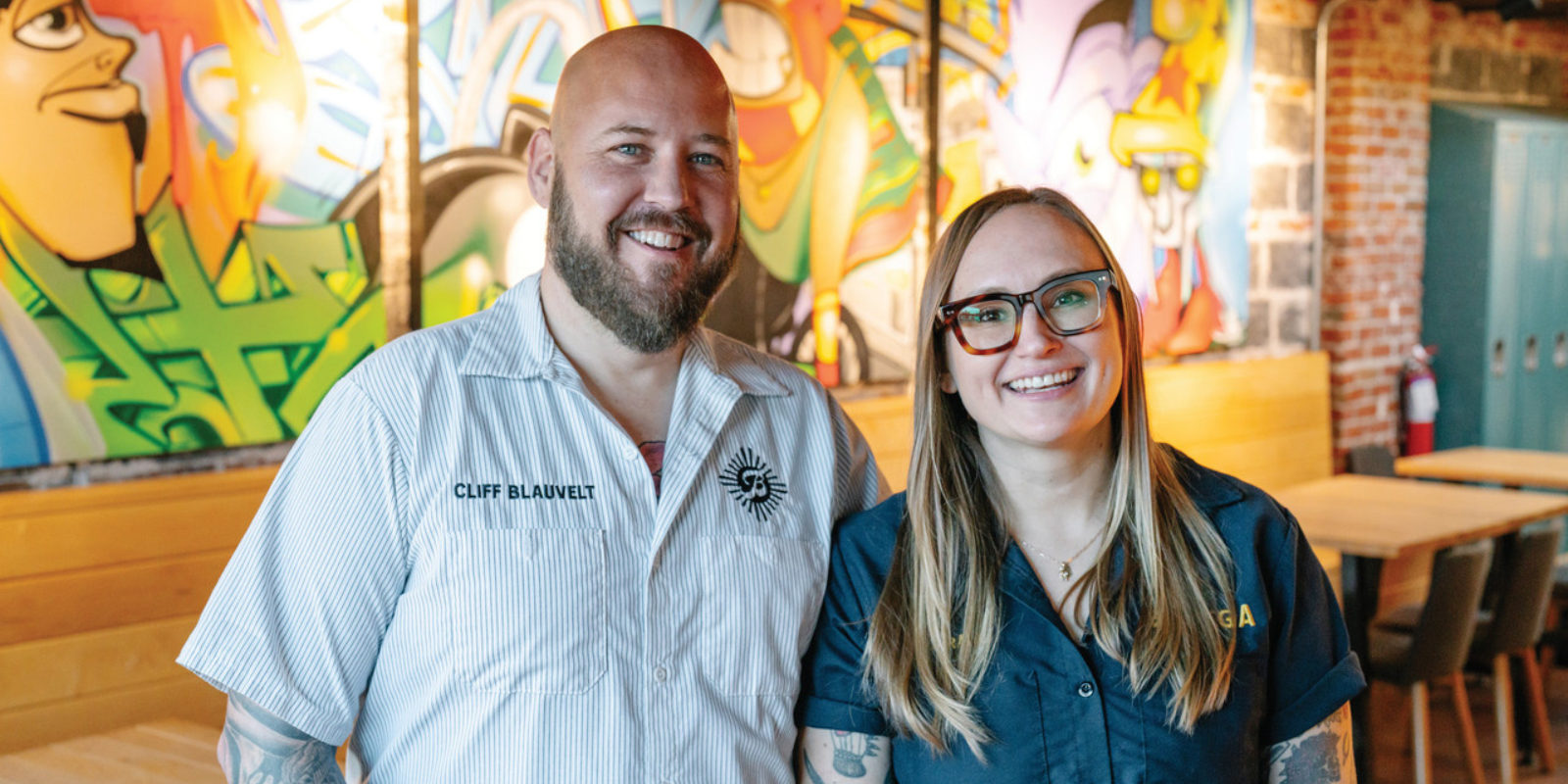 Photo of Cliff and Cara Blauvent smiling and standing next to one another inside Odie B's restaurant. Photo by Behind the Apron Media.